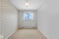 Carpeted spare room featuring a textured ceiling and wallpapered walls - 