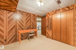 Office space featuring a drop ceiling, light colored carpet, and wooden walls - 