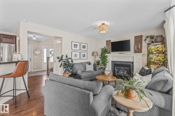 Living area featuring dark wood finished floors, a tile fireplace, and a textured ceiling - 