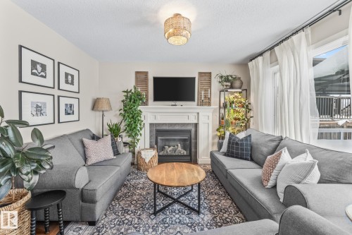Living room with a tiled fireplace and a textured ceiling - 10415 94 Street, Morinville, AB - Indoor Photo Showing Living Room With Fireplace