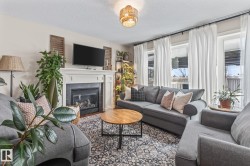 Living area featuring a tiled fireplace, a textured ceiling, and wood finished floors - 