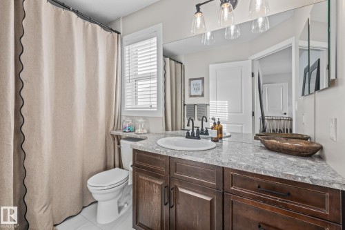 Bathroom with vanity, a shower with curtain, and light tile patterned floors - 10415 94 Street, Morinville, AB - Indoor Photo Showing Bathroom
