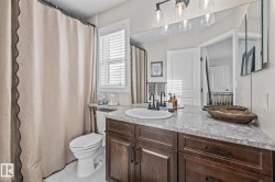 Bathroom with vanity, a shower with curtain, and light tile patterned floors - 