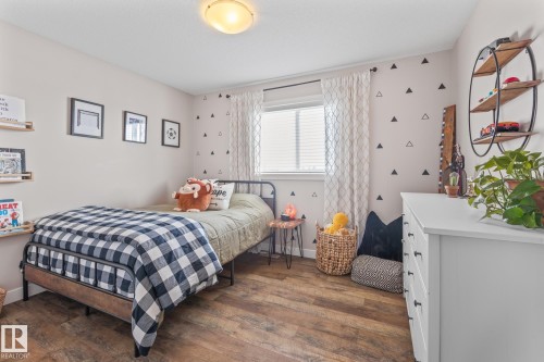 Bedroom with dark wood-type flooring and baseboards - 10415 94 Street, Morinville, AB - Indoor Photo Showing Bedroom