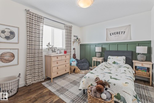 Bedroom with dark wood-style flooring, a decorative wall, and wainscoting - 10415 94 Street, Morinville, AB - Indoor Photo Showing Bedroom