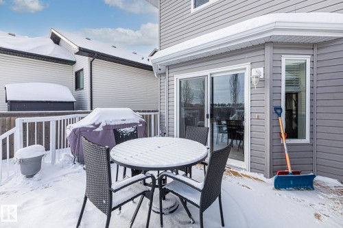 Snow covered patio featuring outdoor dining space, a wooden deck, and grilling area - 10415 94 Street, Morinville, AB - Outdoor With Deck Patio Veranda With Exterior