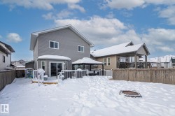 Snow covered back of property featuring a deck, a gazebo, and a fenced backyard - 