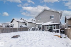 Snow covered rear of property with a gazebo, a fenced backyard, a deck, and a residential view - 
