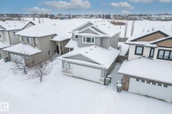 View of front of property with a residential view, stone siding, and a garage - 