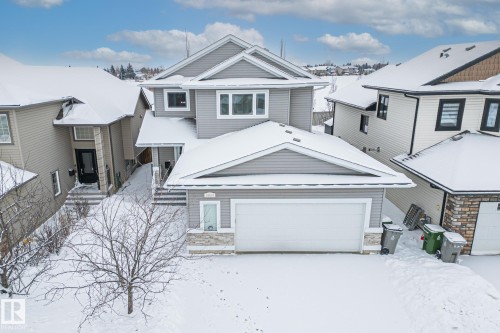 Craftsman inspired home featuring a garage, a residential view, and stone siding - 10415 94 Street, Morinville, AB - Outdoor With Facade