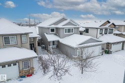 Craftsman inspired home with stone siding, a residential view, and a garage - 