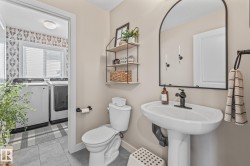 Bathroom with washer and dryer and light tile patterned floors - 