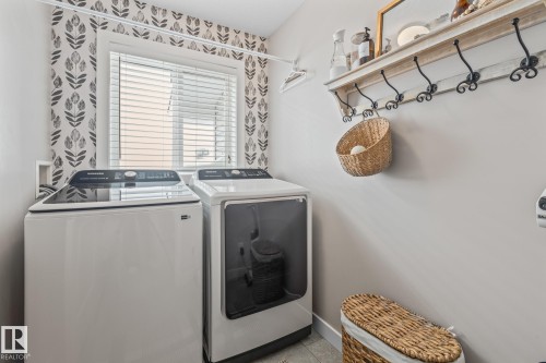 Laundry area with independent washer and dryer and baseboards - 10415 94 Street, Morinville, AB - Indoor Photo Showing Laundry Room