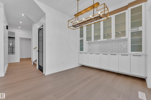 Unfurnished dining area with light wood-style floors and suspended lighting - 95 Eldridge Point(E), St. Albert, AB - Indoor Photo Showing Other Room