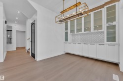 Unfurnished dining area with light wood-style floors and suspended lighting - 