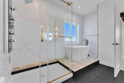 Bathroom featuring a marble finish shower, a freestanding bath, recessed lighting, and dark tile patterned floors - 95 Eldridge Point(E), St. Albert, AB - Indoor Photo Showing Bathroom