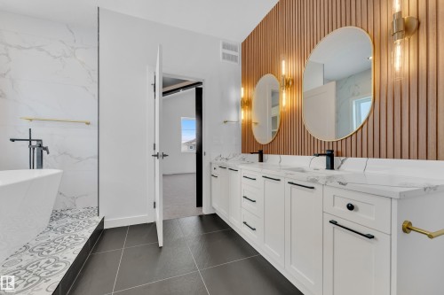 Bathroom featuring double vanity, a soaking tub, and dark tile patterned floors - 95 Eldridge Point(E), St. Albert, AB - Indoor Photo Showing Bathroom
