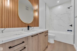 Bathroom with vanity,  shower combination, light wood-type flooring, wallpapered walls, and recessed lighting - 