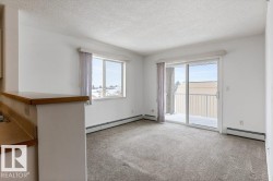 Carpeted spare room featuring a baseboard radiator and a textured ceiling - 