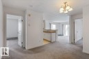 Unfurnished room with light carpet, suspended lighting, a textured ceiling, and a baseboard heating unit - 403 14708 50 Street, Edmonton, AB  - Indoor Photo Showing Other Room 