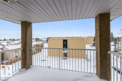 Snow covered back of property with a residential view - 