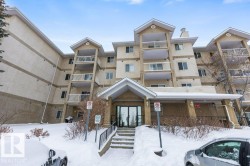Snow covered building featuring a view of apartment building / complex - 