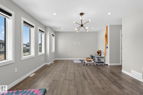 Unfurnished dining area featuring a chandelier and dark wood-style floors - 1027 150 Avenue, Edmonton, AB - Indoor Photo Showing Other Room
