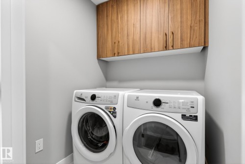 Laundry room featuring cabinet space and separate washer and dryer - 1027 150 Avenue, Edmonton, AB - Indoor Photo Showing Laundry Room