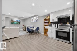 Kitchen featuring stainless steel appliances, white cabinetry, light countertops, open shelves, and recessed lighting - 