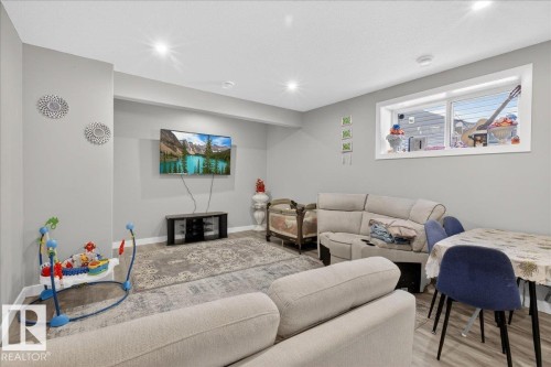 Bedroom featuring a crib, light wood-style floors, a textured ceiling, and a walk in closet - 1027 150 Avenue, Edmonton, AB - Indoor