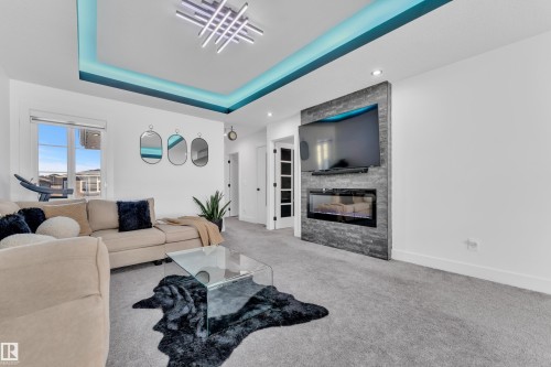 Carpeted living area featuring a fireplace and a raised ceiling - 316 42 Street, Edmonton, AB - Indoor Photo Showing Living Room With Fireplace