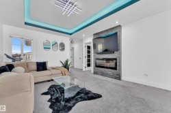 Carpeted living area featuring a fireplace and a raised ceiling - 