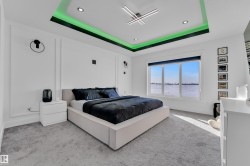 Carpeted bedroom featuring a water view, recessed lighting, and a tray ceiling - 