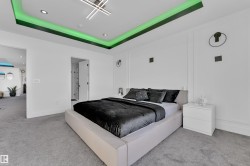 Carpeted bedroom with a raised ceiling and recessed lighting - 