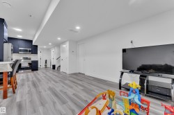 Playroom with light wood-style flooring, recessed lighting, and a glass covered fireplace - 