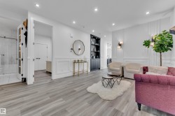 Living room with a decorative wall, light wood finished floors, wainscoting, and recessed lighting - 