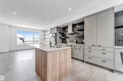 Two tone kitchen with two tone color scheme, a center island with sink, backsplash, open shelves, and modern cabinets - 