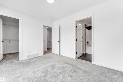 Unfurnished bedroom featuring a spacious closet, carpet flooring, and ensuite bathroom - 