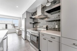 Kitchen featuring open shelves, stainless steel appliances, light countertops, recessed lighting, and backsplash - 