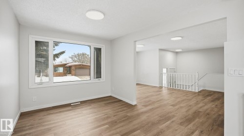 Unfurnished room featuring a textured ceiling and light wood-style floors - 3419 143 Avenue Nw, Edmonton, AB - Indoor Photo Showing Other Room