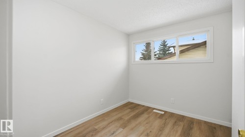 Empty room with light wood-type flooring and a textured ceiling - 3419 143 Avenue Nw, Edmonton, AB - Indoor Photo Showing Other Room