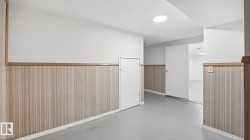 Empty room featuring wainscoting, finished concrete floors, and a textured ceiling - 