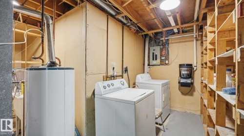 Laundry area with water heater, concrete flooring, washer and clothes dryer, and electric panel - 3419 143 Avenue Nw, Edmonton, AB - Indoor Photo Showing Laundry Room