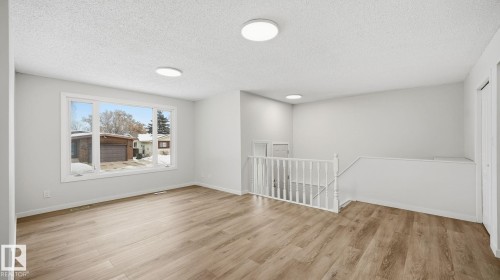 Family room with a textured ceiling and light wood-type flooring - 3419 143 Avenue Nw, Edmonton, AB - Indoor