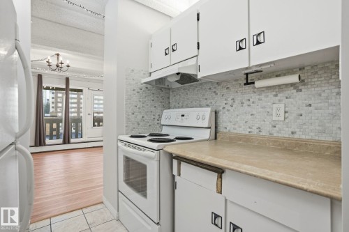 Kitchen featuring white appliances, white cabinets, light countertops, and light tile patterned floors - 1103 9918 101 Street, Edmonton, AB - Indoor Photo Showing Kitchen