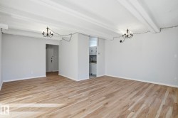 Unfurnished dining area with suspended lighting, beam ceiling, and light wood finished floors - 