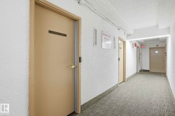 Hall featuring a textured wall and a textured ceiling - 