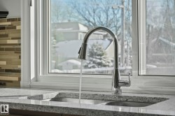 Kitchen view of a sink and light stone countertops - 