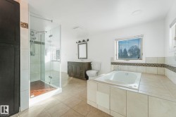 Bathroom with light tile patterned floors, a stall shower, a garden tub, vanity, and healthy amount of natural light - 