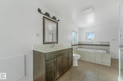 Full bathroom featuring a bath, vanity, and light tile patterned floors - 